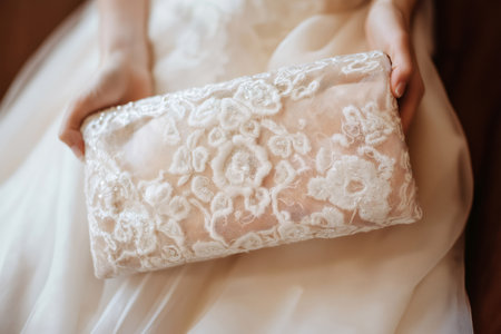 Close up of a bride holding a beautiful clutch bag adorned with sequins and lace, adding a touch of elegance to her wedding attireの素材