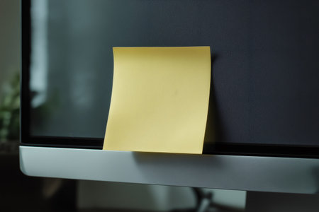 Yellow sticky note resting on a computer screen, inviting fresh ideas in a modern office environment filled with creativity and innovationの素材
