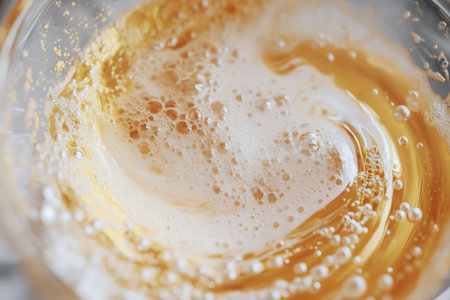 Close up macro shot of swirling beer creating foam and bubbles, perfect for beverage and refreshment themesの素材