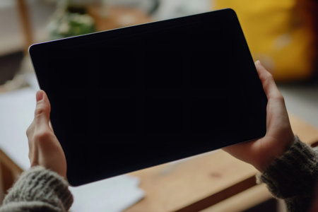 Person holding a digital tablet with a blank screen horizontally, providing copy space for technology and lifestyle conceptsの素材