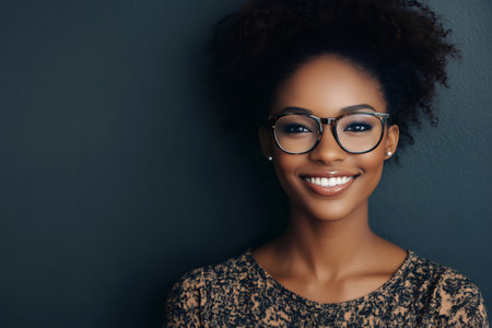 Confident young black woman wearing stylish glasses and smiling, representing professionalism, happiness, and clear visionの素材