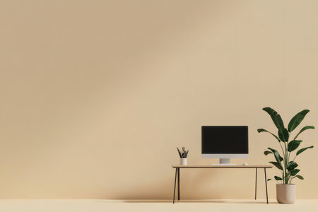 Minimalist desk with a clean computer setup and a green houseplant, creating a tranquil and modern workspace or study areaの素材