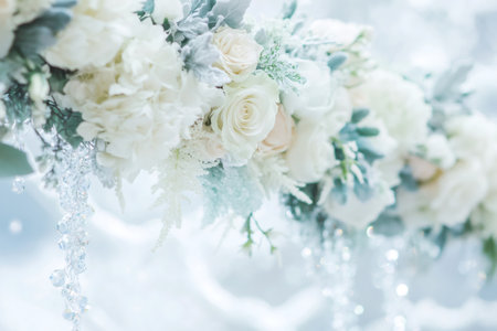 Delicate white flowers and dusty miller foliage decorating an elegant wedding setup. Sparkling crystals add a glamorous touchの素材