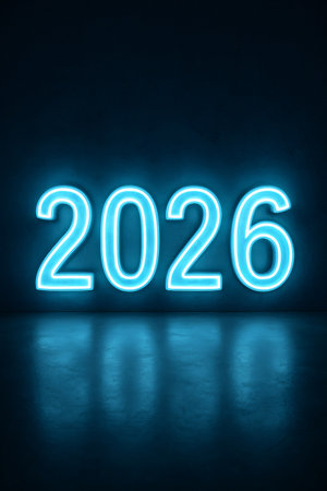 2026 number glowing with blue neon light against a dark concrete wall, reflecting on a polished floor. New Year conceptの素材