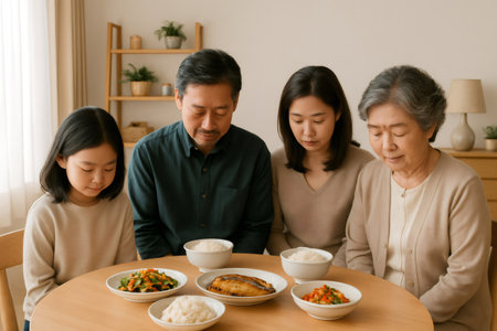 Multi generation Asian family praying or showing gratitude together at dining table before enjoying a traditional home cooked mealの素材