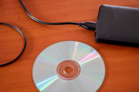 External hard drive on wood background.