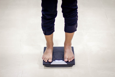 woman Standing On Weighing white backgroundの写真素材