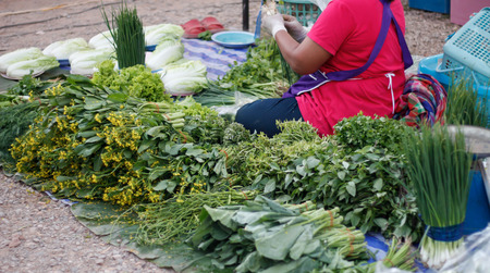 woman sells vegetable at morning marketの写真素材