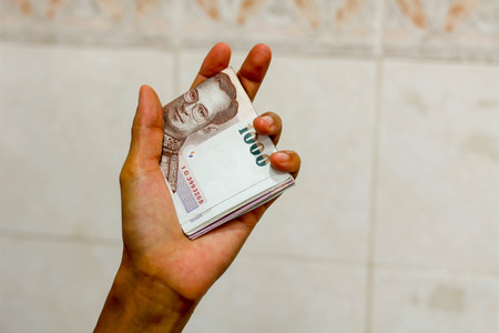 Hand holding Thailand banknoteの写真素材