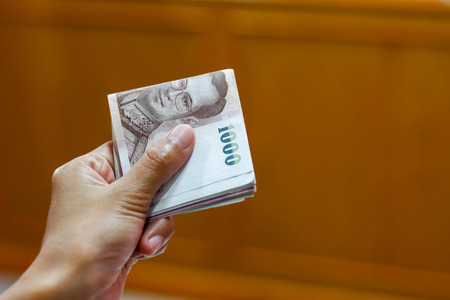 Hand holding Thailand banknote