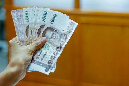 Hand holding Thailand banknoteの写真素材