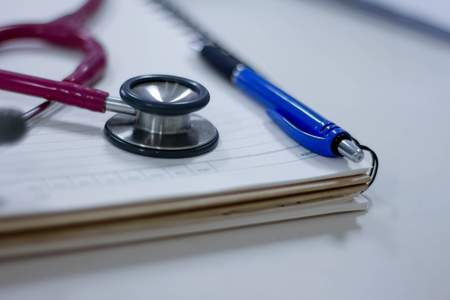 Stethoscope with paper and pen on white background on white backgroundの写真素材