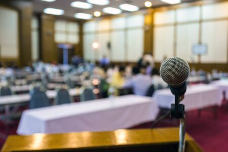 blurred meeting room and selective focus on head of microphoneの写真素材
