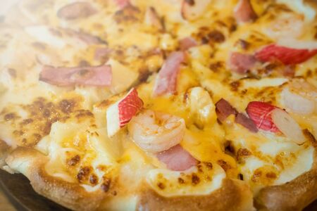 Pizza with a mixture of shrimp, crab, cheese, ham, pineapple.の写真素材
