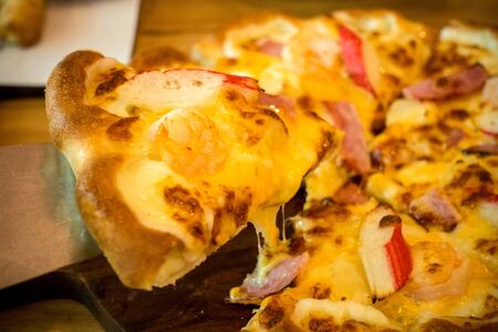 Pizza with a mixture of shrimp, crab, cheese, ham, pineapple.の写真素材