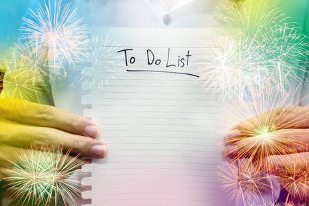 man in white shirt hold paper to do list with double exposure firework. concept list of celebration planの写真素材
