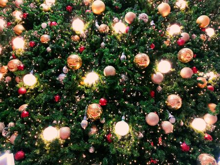 Christmas tree decorated with bulbs and red, golden ballsの写真素材