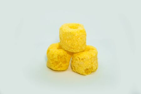 Baked corn snacks in tube shape on a white backgroundの写真素材