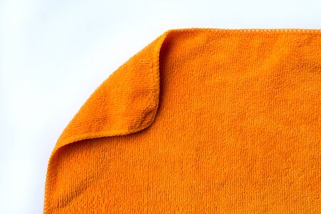 folded orange towel placed on white backgroundの写真素材