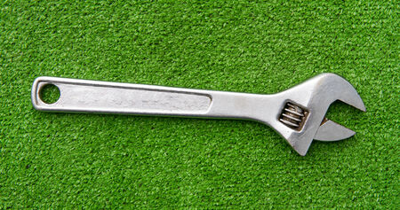 Close up, spanner on artificial grass background.