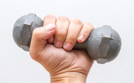 Left hand hold small dumbbell on white wall background.の写真素材