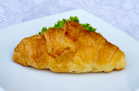 Sandwich croissant with vegetable on white plate.の写真素材