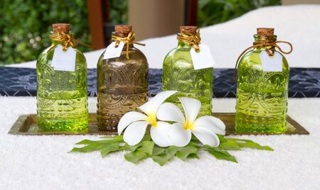 Bottles of essential oils placed on the bed decoration leelawadee flower at spa.の写真素材