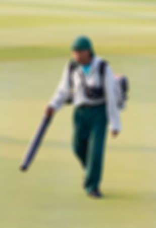 Blur, Man worker tool blower leaf and grass on putting green at golf course in the morning.