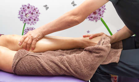 Close up, female hand doing leg massageの写真素材