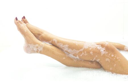 Woman is covered with a foam bath  She is taking a bath  She is washing and playing and smiling  の写真素材