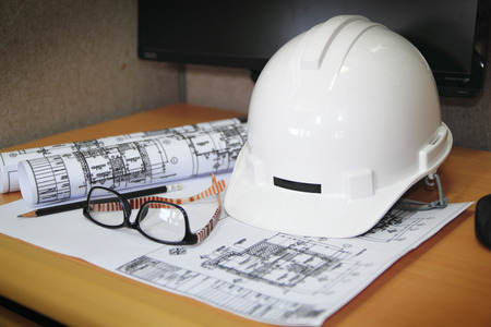 file of safety helmet and architect plant on wood tableの写真素材
