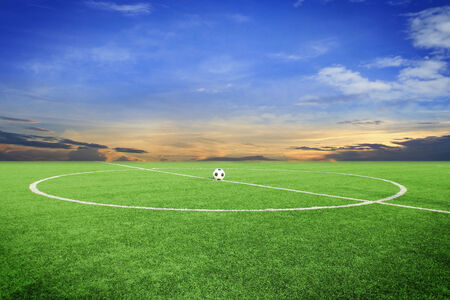 soccer ball on soccer field with blue skyの写真素材