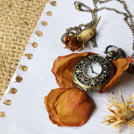 Vintage pocket watch with dry roseの写真素材