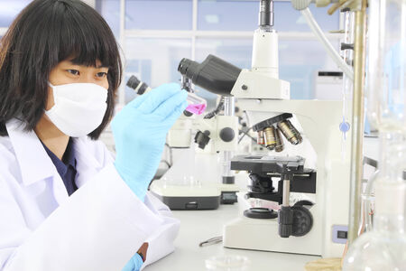 Chemist holding sample of liquid in lab or laboratoryの写真素材