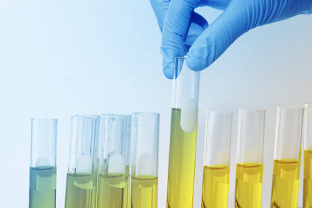 Chemist holding sample of liquid in lab or laboratory