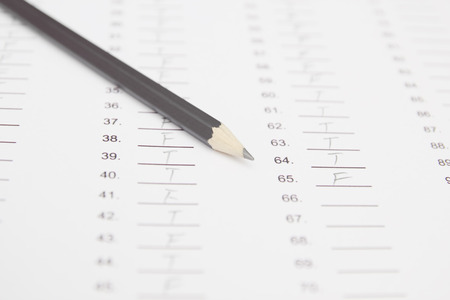 Standardized test form with answers and a pencil, focus on anser sheet