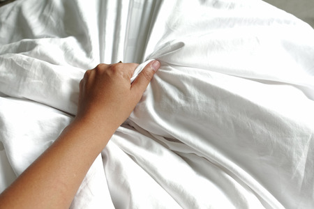 hand of women pulling white sheets in ecstasy, orgasm.