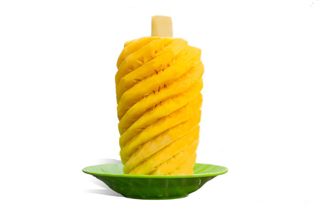 Fresh peeled pineapple on green plateの写真素材
