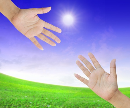 A hand is reaching out in the sky for helpの写真素材