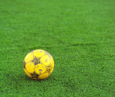 old soccer ball on green grass の写真素材