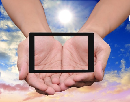 Hand to hold card, mobile phone, tablet PC on blue skyの写真素材