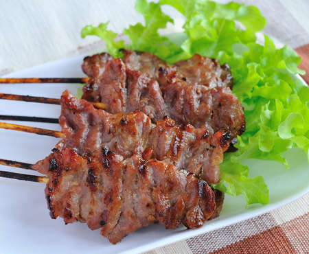 pork steak with vegetables served on a white plate の写真素材