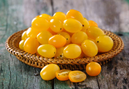 yellow tomato on wooden tableの写真素材