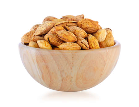 almonds in wood bowl isolated on white backgroundの写真素材