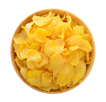 corn flakes in wood bowl isolated on white background