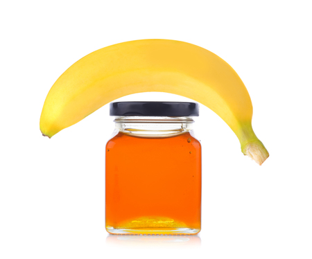 honey jar and banana on white backgroundの写真素材
