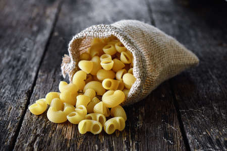 macaroni In the sack on wood tableの写真素材