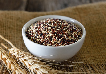 Quinoa seeds in bowl on woodの写真素材