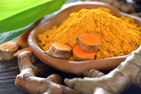 Turmeric powder on wooden backgroundの写真素材