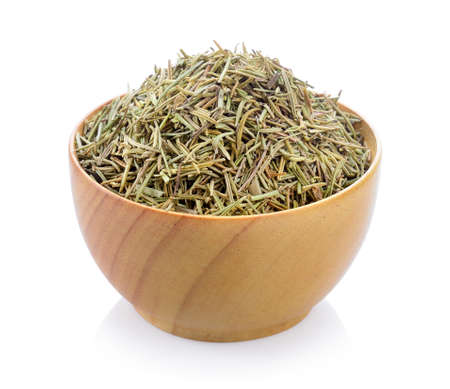 Dried rosemary leaves in wooden bowl over white backgroundの写真素材